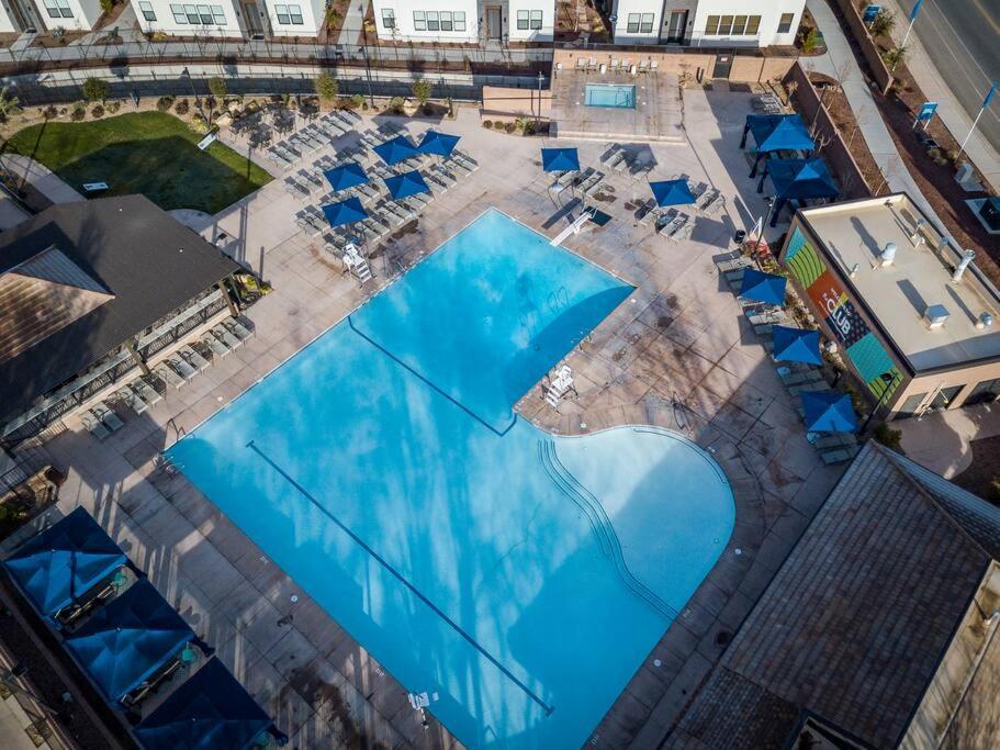 an overhead view of a pool with blue umbrellas at Villa 18 - 4 Bedroom! YEAR ROUND HEATED POOL & HOT TUB! GAMES! GOLF! TENNIS! in St. George