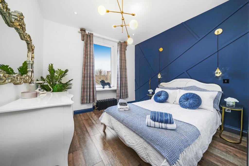 a blue bedroom with a bed and a blue wall at Roslin Place - Grampian Lettings Ltd in Aberdeen