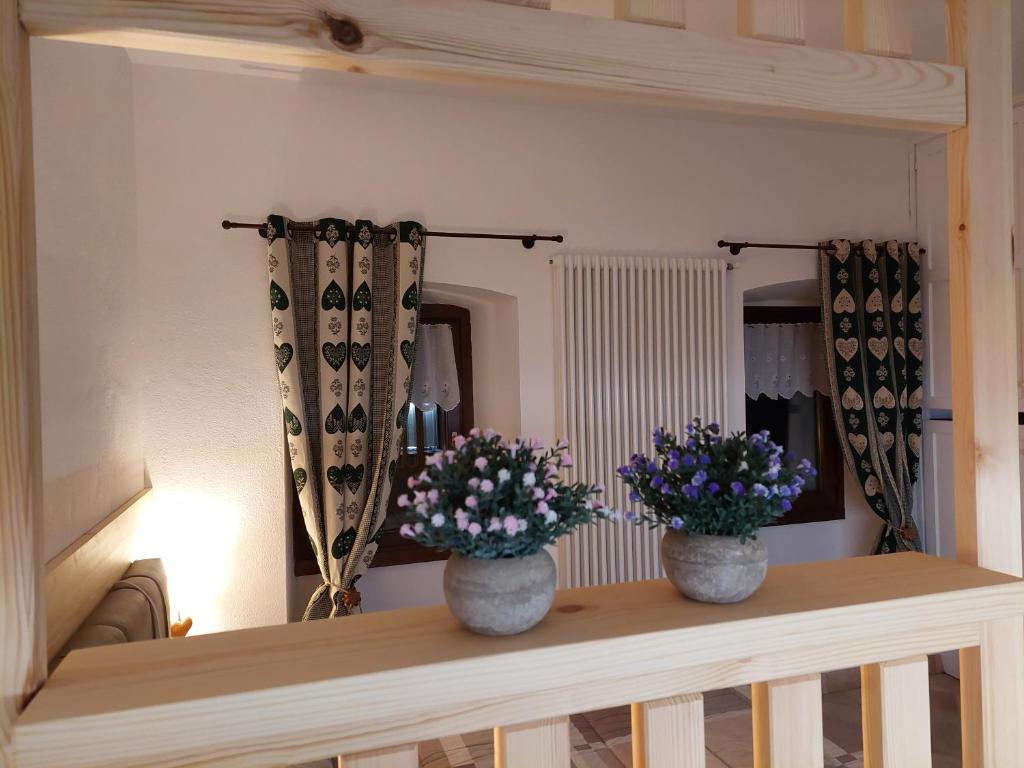 dos jarrones de flores en una mesa en una habitación en Galanthus, en Aosta