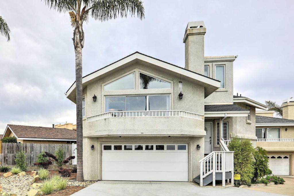 a house with a white garage door and a palm tree at Ideally Located Ocean Escape Near Beach and Wineries in Grover Beach