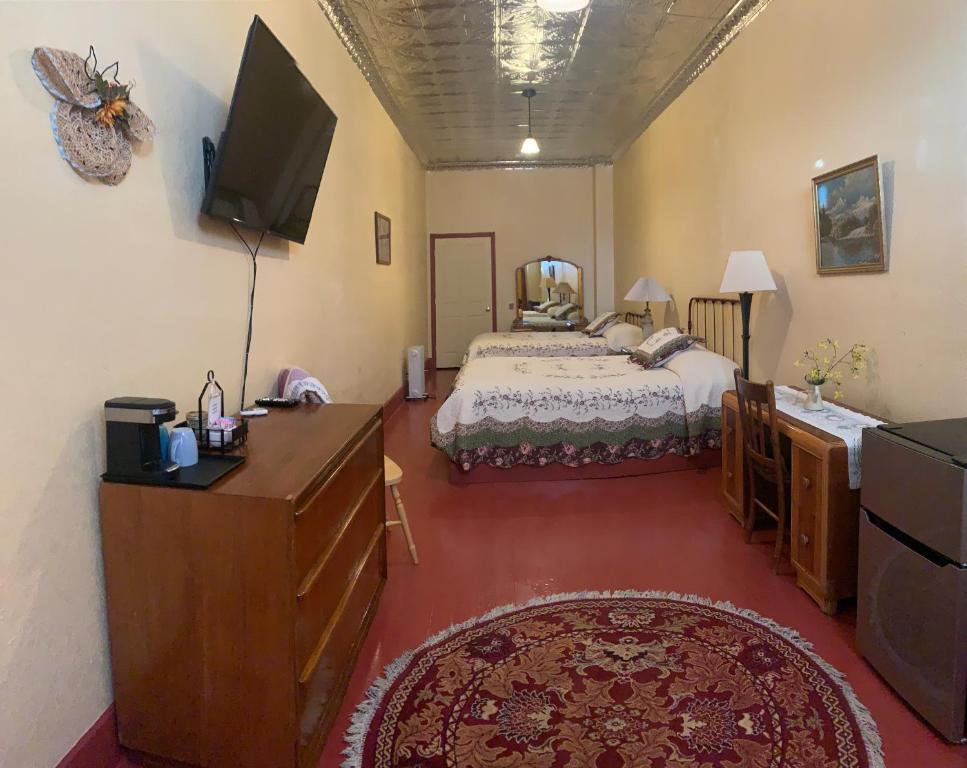 1 dormitorio con 1 cama y TV de pantalla plana en Historic Hotel Greybull, en Greybull