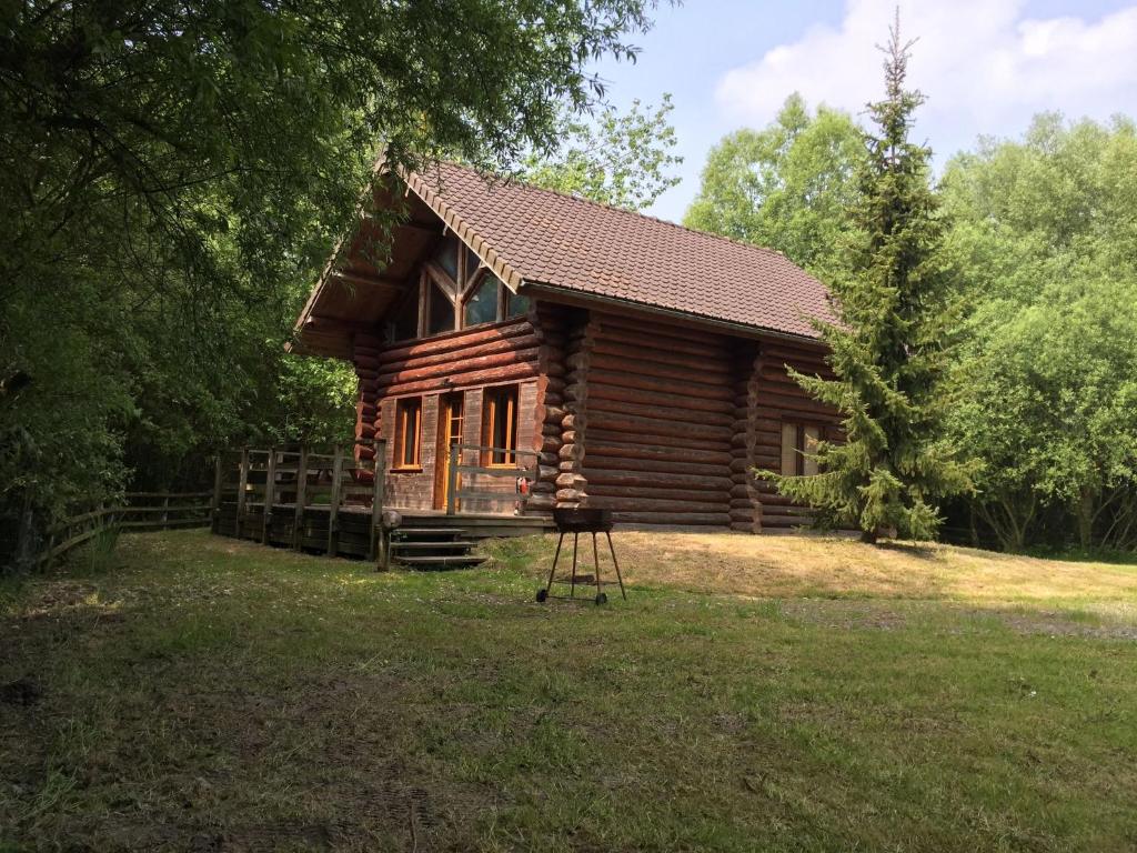 a log cabin in the middle of a yard at Charming Chalet with Swimming Pool in Quend in Quend