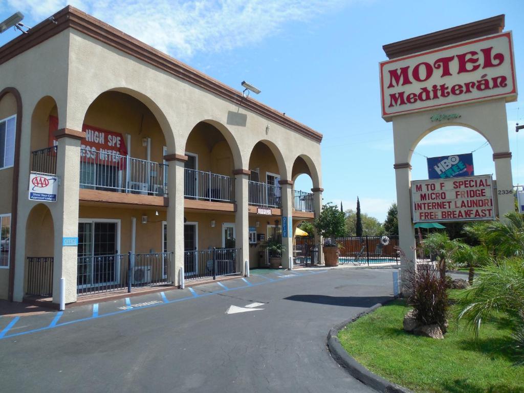 a motel with a sign in front of a building at Motel Mediteran in Escondido