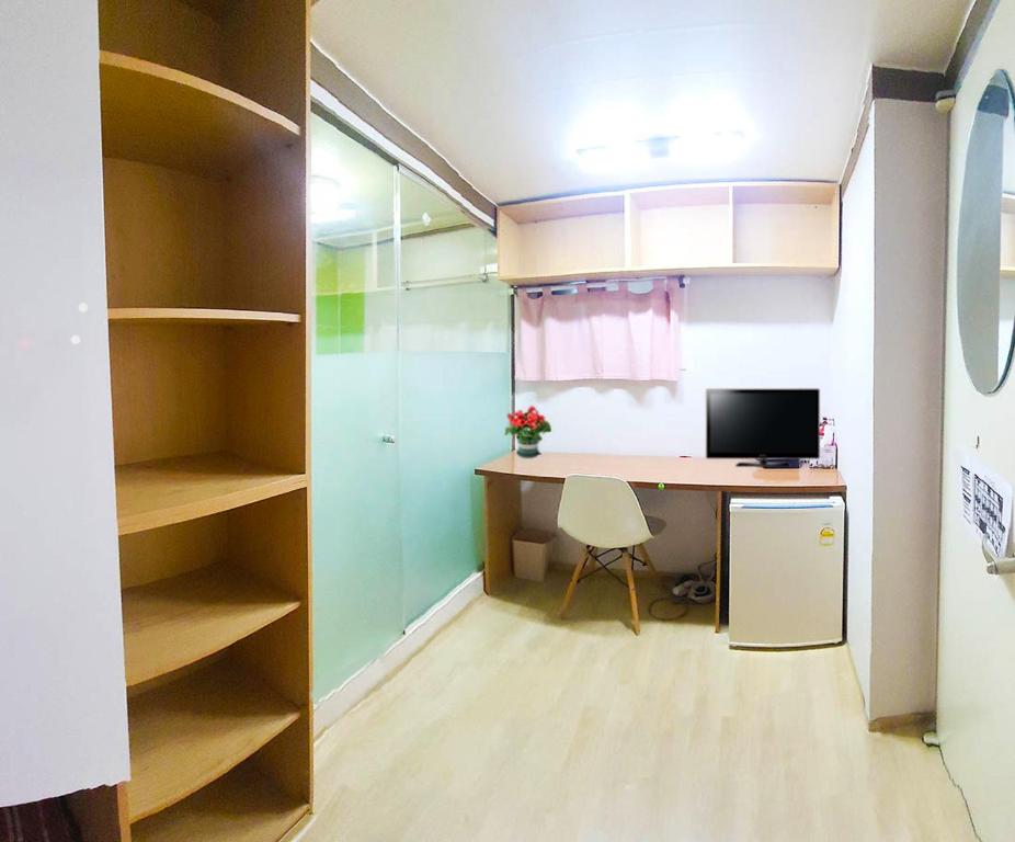 a room with a desk with a computer and a closet at Asan Residence in Seoul