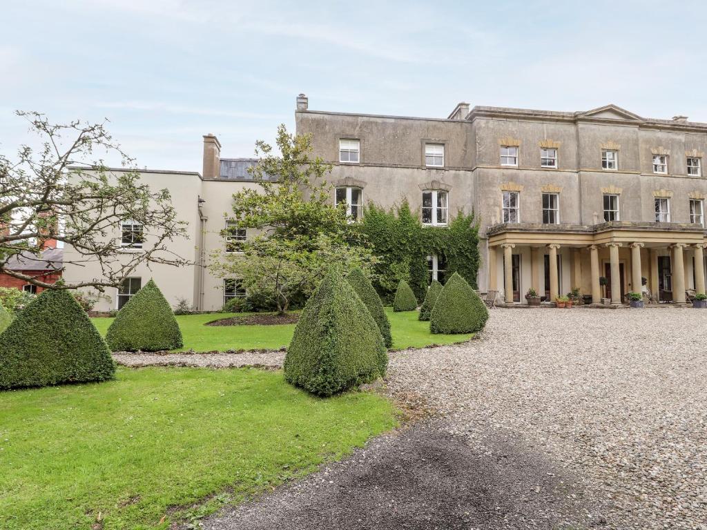 a large mansion with trees in front of it at Cook's Flat in Wrexham