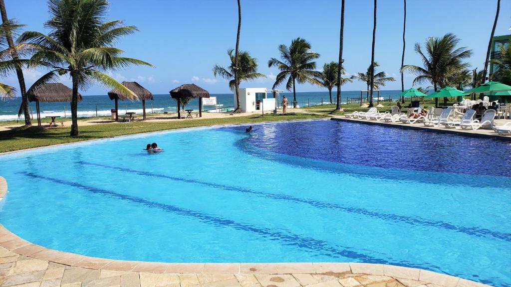 eine Person in einem Pool neben dem Strand in der Unterkunft Ancorar Resort Vista Mar Flat 6103 in Porto De Galinhas