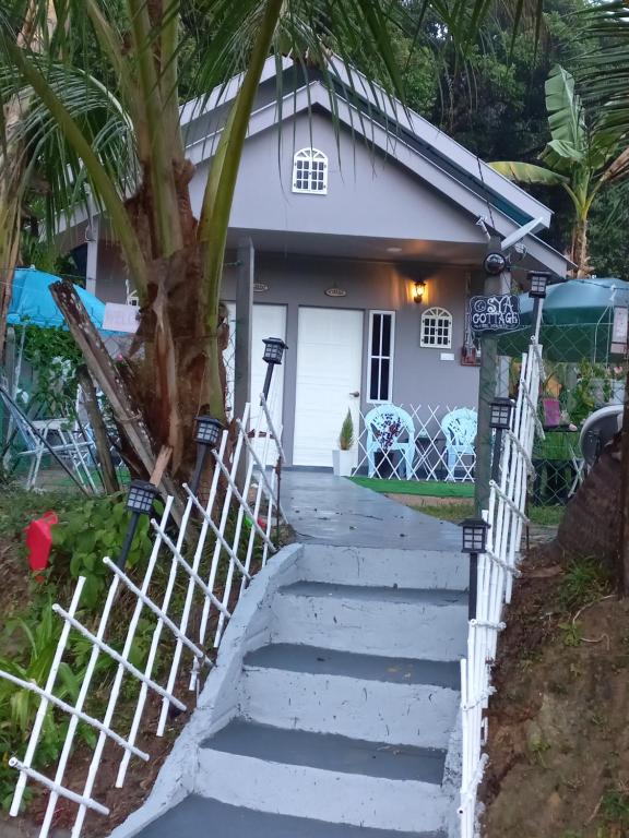 uma casa com escadas que levam à porta da frente em Sya Cottage em Kuala Pilah