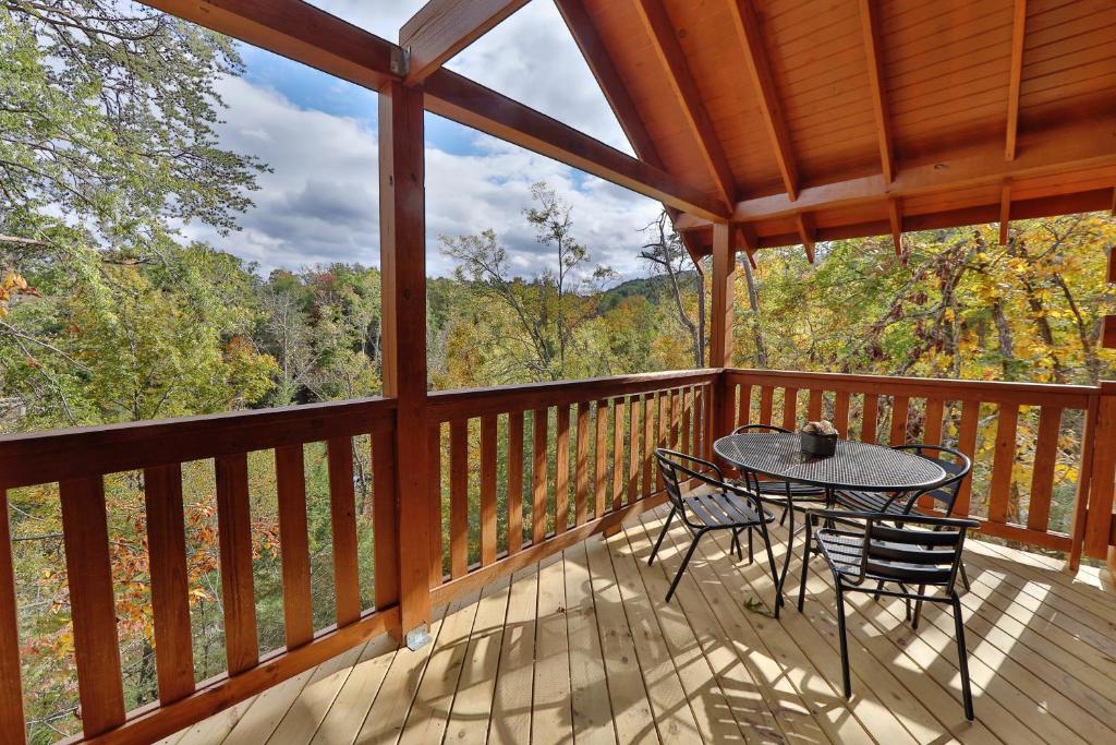 una veranda riparata con tavolo e sedie sopra di Deer Pass Lodge a Pigeon Forge
