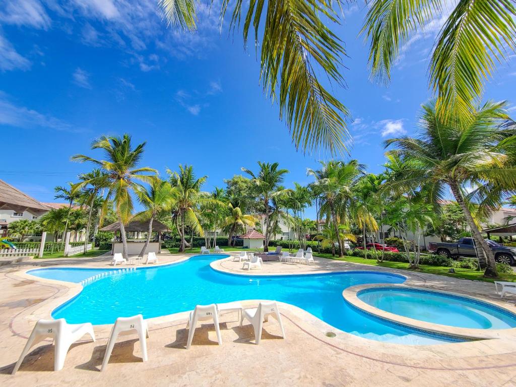 a swimming pool with chairs and palm trees at Blue Heaven Guest House Bávaro, Punta Cana, Ideal For Couples in Punta Cana