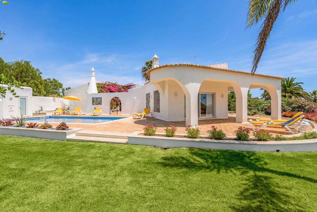 a villa with a swimming pool and a yard at Casa Janus in Carvoeiro