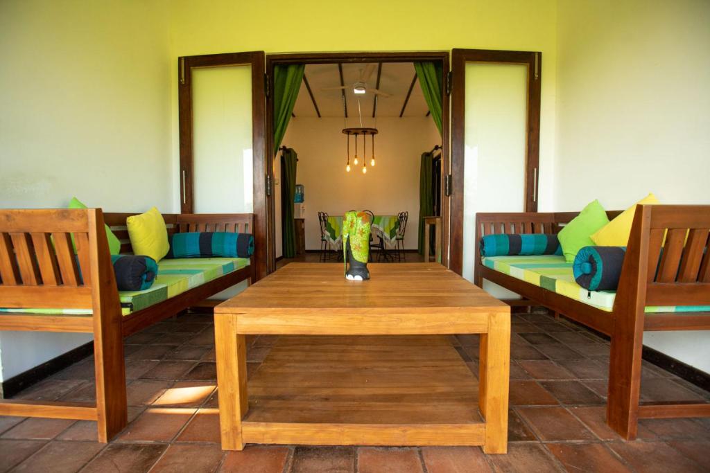 Una habitación con sofás y una mesa con un jarrón. en Wild Edge - Wilpattu en Nochchiyagama