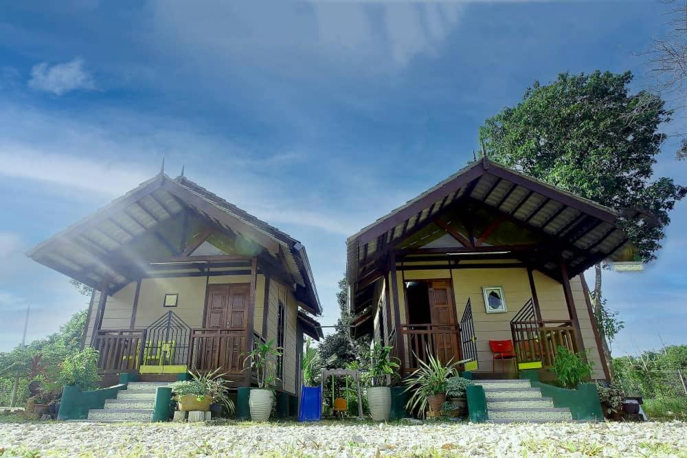 un par de casas con algunas plantas delante de ellas en Laman Sakinah Merlimau en Merlimau