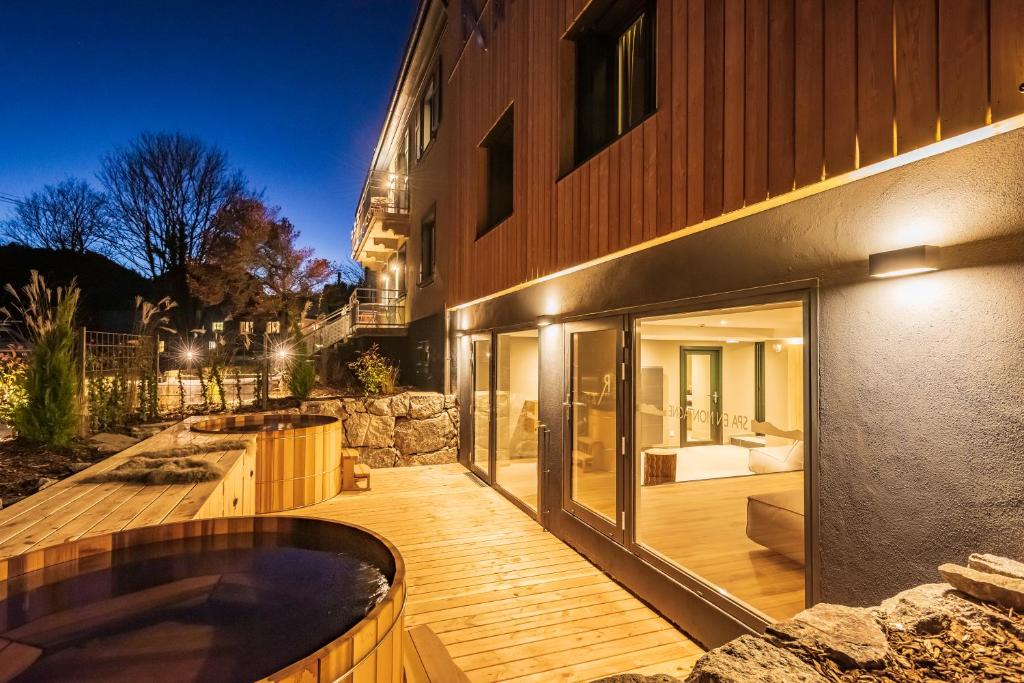 a wooden deck with a hot tub next to a building at Logis Hôtel Restaurant & Spa La Rochette in Labaroche
