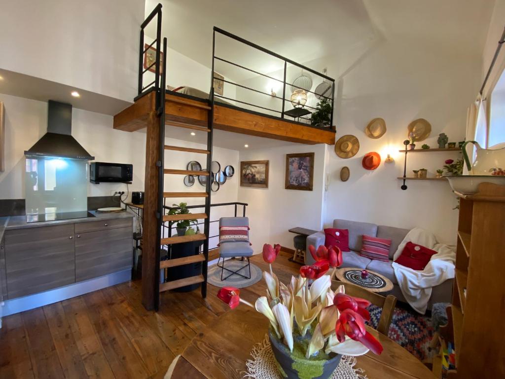een woonkamer met een hoogslaper en een keuken bij Duplex cosy au cœur de Barcelonnette in Barcelonnette