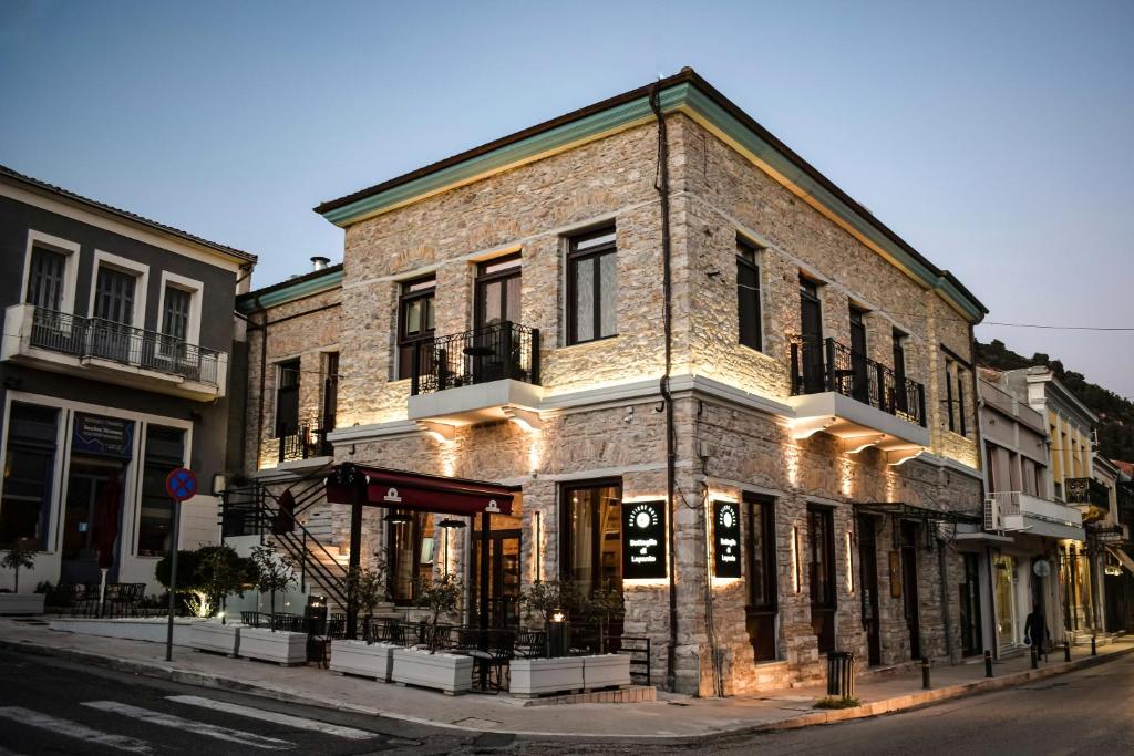 un bâtiment en briques avec des lumières sur le côté d'une rue dans l'établissement Battaglia di Lepanto, à Naupacte