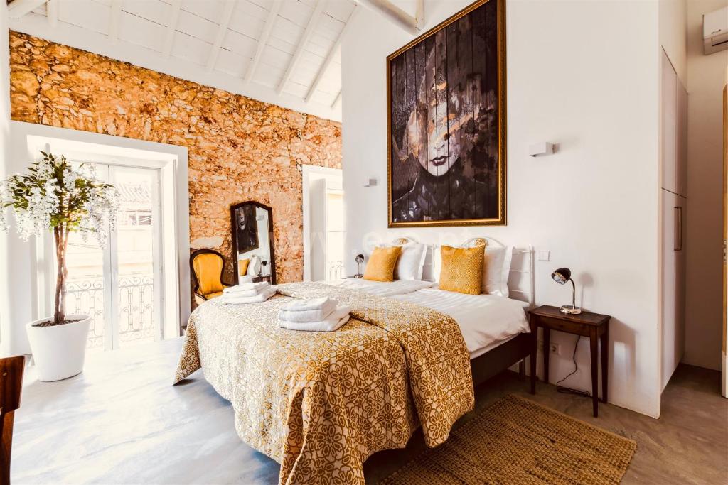 a bedroom with a large bed with a table at Alma da Vida Ferragudo in Ferragudo