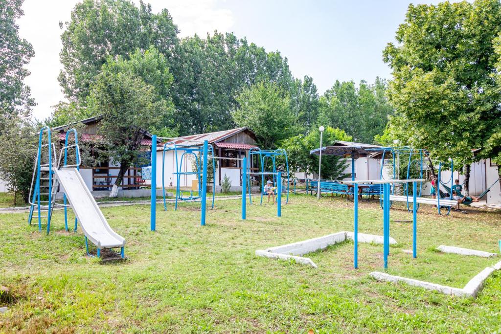 a playground with a bunch of swings and slides at Bungalow Silitur in Ahtopol