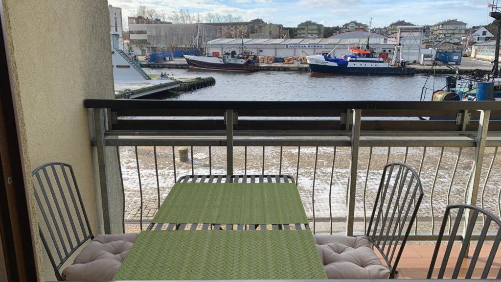 balkon ze stołem i krzesłami oraz widokiem na wodę w obiekcie Apartament Portowe Wspomnienia w Ustce