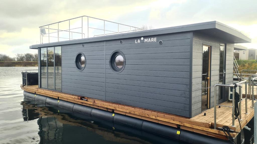 a tiny house on a dock on the water at Hausboot La Mare Emma in Weyhe