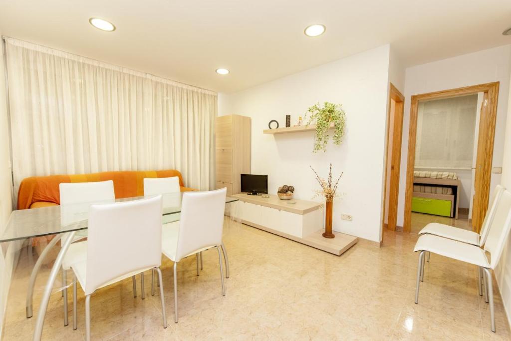 a living room with a table and white chairs at Ermitana 6 in Peñíscola