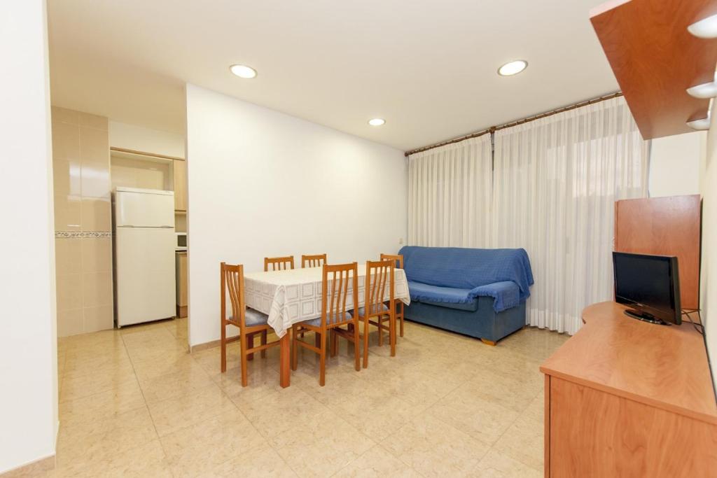- un salon avec une table et un canapé bleu dans l'établissement Ermitana 4, à Peñíscola