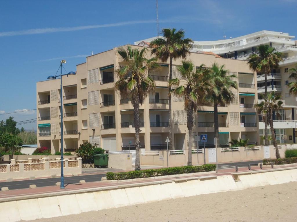 um edifício de apartamentos na praia com palmeiras em Los Monegros em Peñíscola