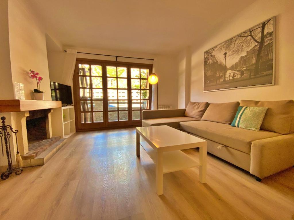 ein Wohnzimmer mit einem Sofa und einem Kamin in der Unterkunft Agols, Canillo Centro, Zona Grandvalira in Canillo