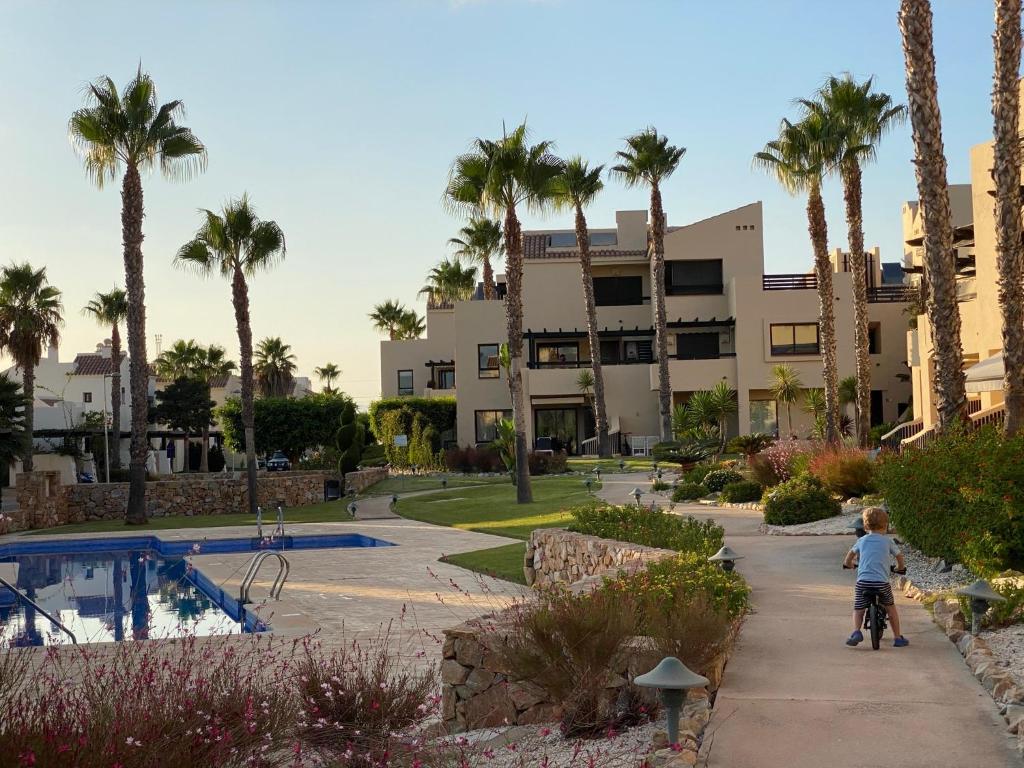 a little boy walking down a sidewalk in front of a resort at Magnifique appartement dans Roda Golf (phase 4) in San Javier