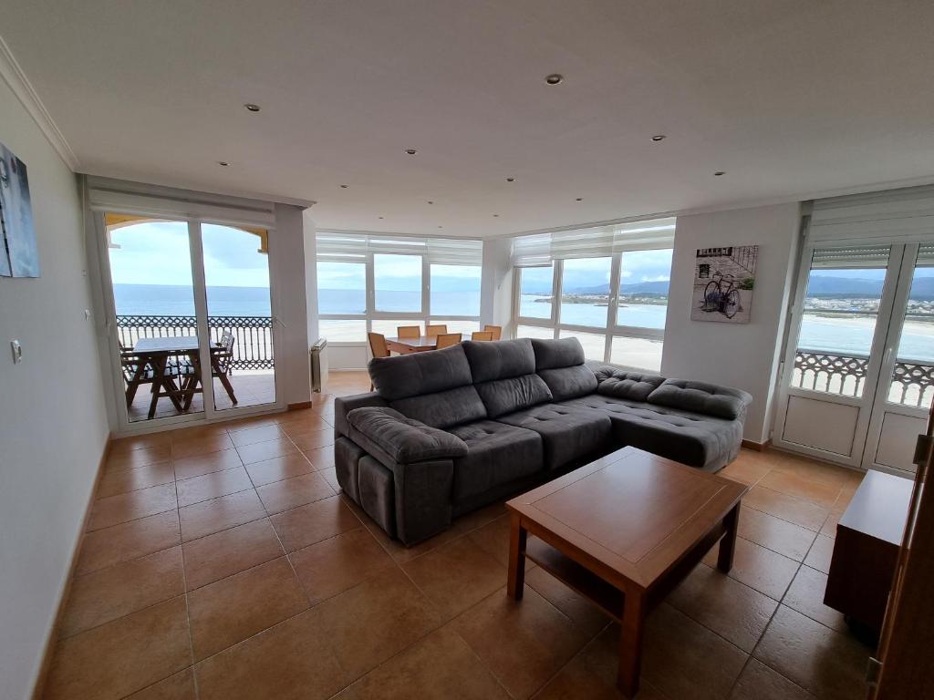 uma sala de estar com um sofá e uma mesa em Dúplex 4 dormitorios en Playa Rapadoira em Foz