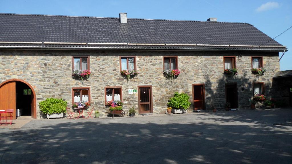 un edificio de ladrillo con flores en las ventanas en A mon Châl, en Waimes