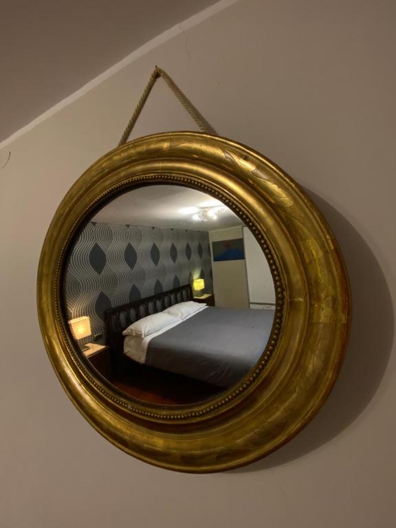 Magione Serra في نابولي: مرآة على جدار مع سرير في غرفة