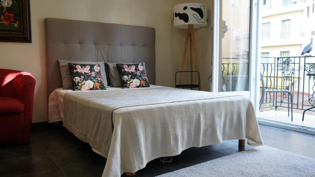 - une chambre avec un lit doté d'une couverture blanche et d'une fenêtre dans l'établissement Cozy studio with a sea view, à Nice