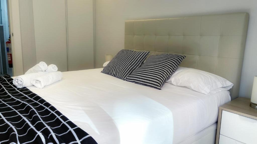Una cama blanca con dos almohadas encima. en Caminando al Guggenheim by Urban Hosts, en Bilbao