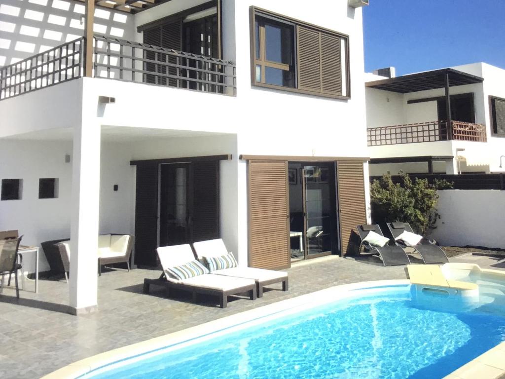 dom z basenem przed domem w obiekcie Modern villa with sea views w Costa Teguise