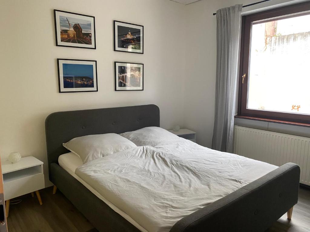 un letto in una camera da letto con immagini appese al muro di Ferienwohnung Bienengarten a Bingen am Rhein