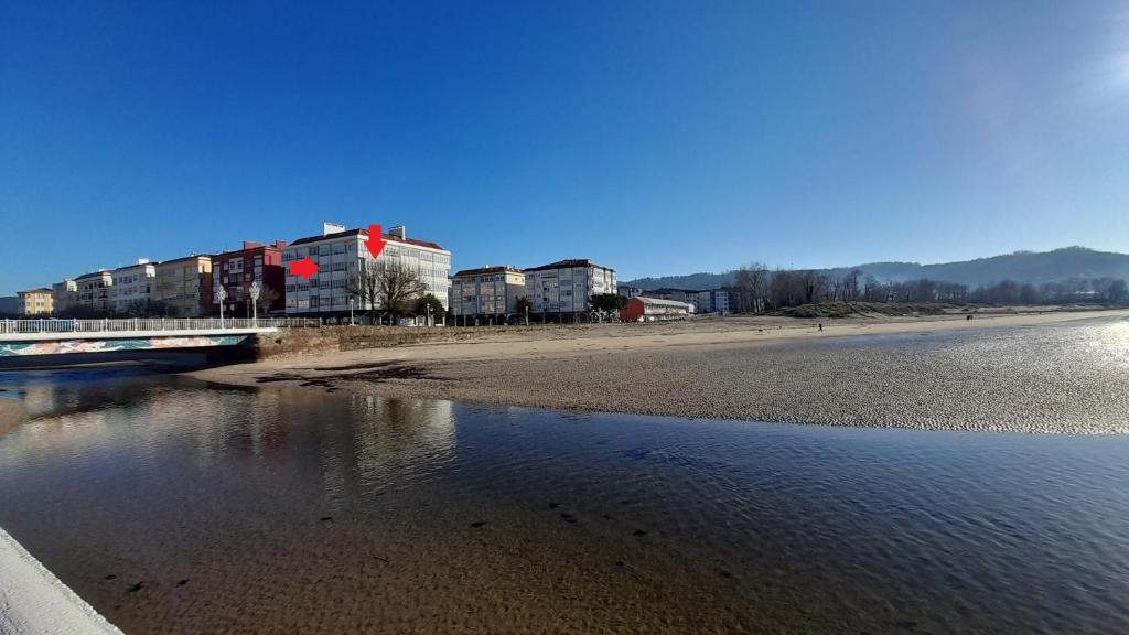 un tren está cruzando un puente sobre un cuerpo de agua en A Tonera (Praza Roxa) en Cedeira