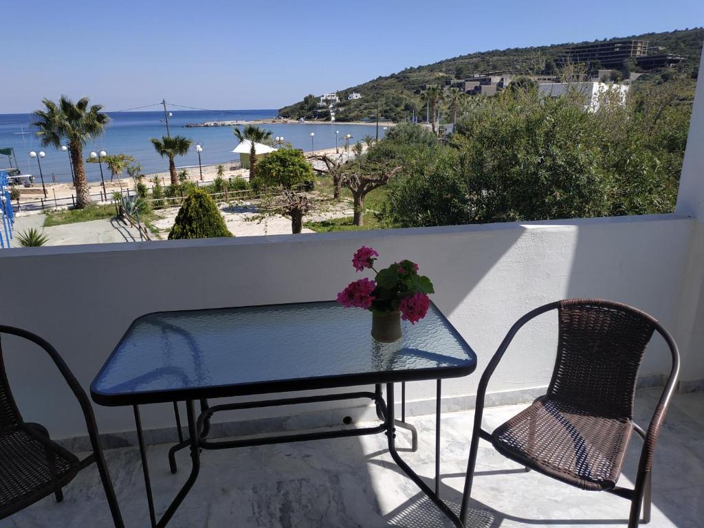 a table and chairs on a balcony with a view of the beach at Παραθαλασσια στουντιο Μιχαλιας Sea view studio Michalias in Agia Marina Aegina