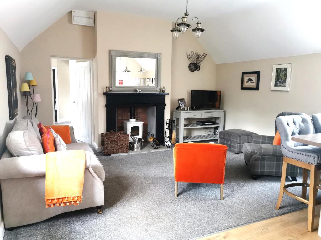 a living room with a couch and a fireplace at The Courtyard Apartment at Cefn Tilla Court, Usk in Usk