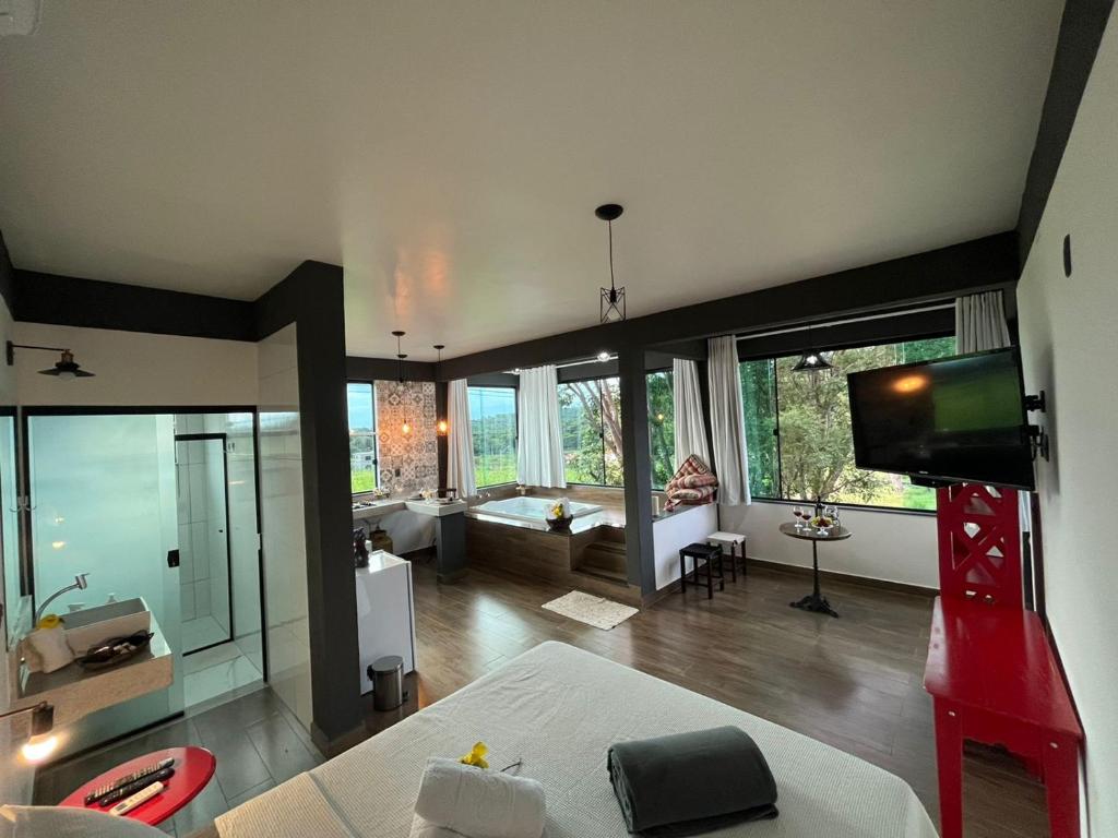 a large living room with a television and a couch at Solar das Aroeiras in Serra do Cipo