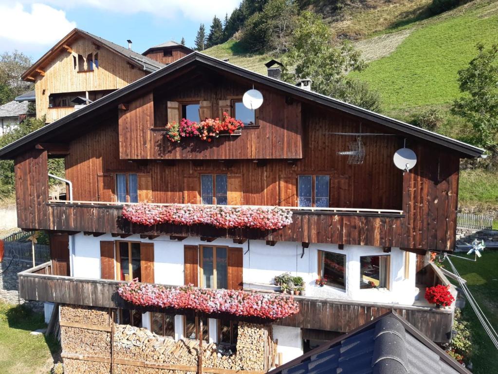 a wooden house with flowers in the windows at Lü de Terza in San Vigilio Di Marebbe