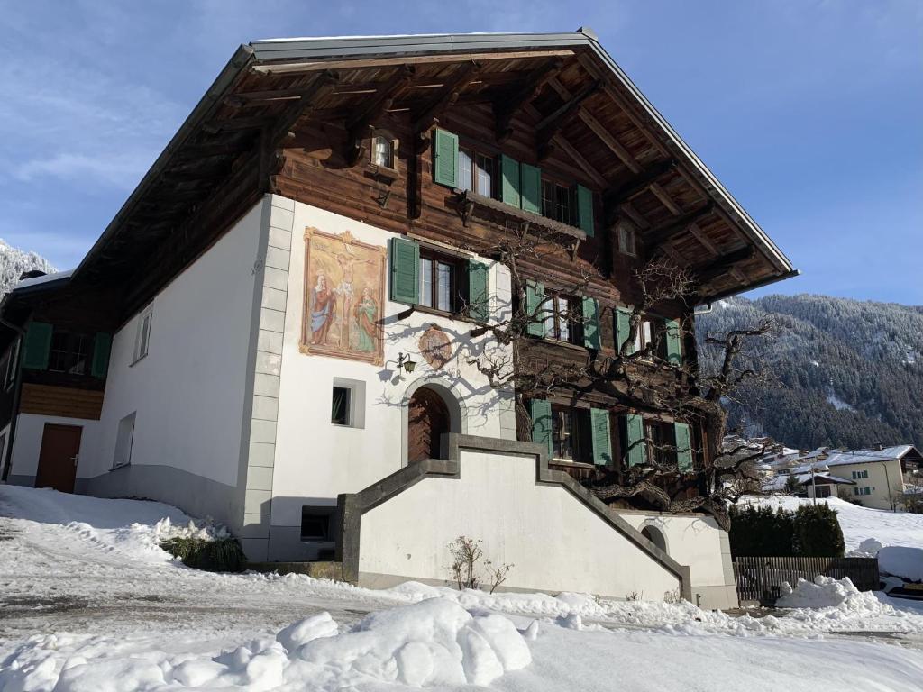 um grande edifício com neve no chão em Haus Mangard em Sankt Gallenkirch