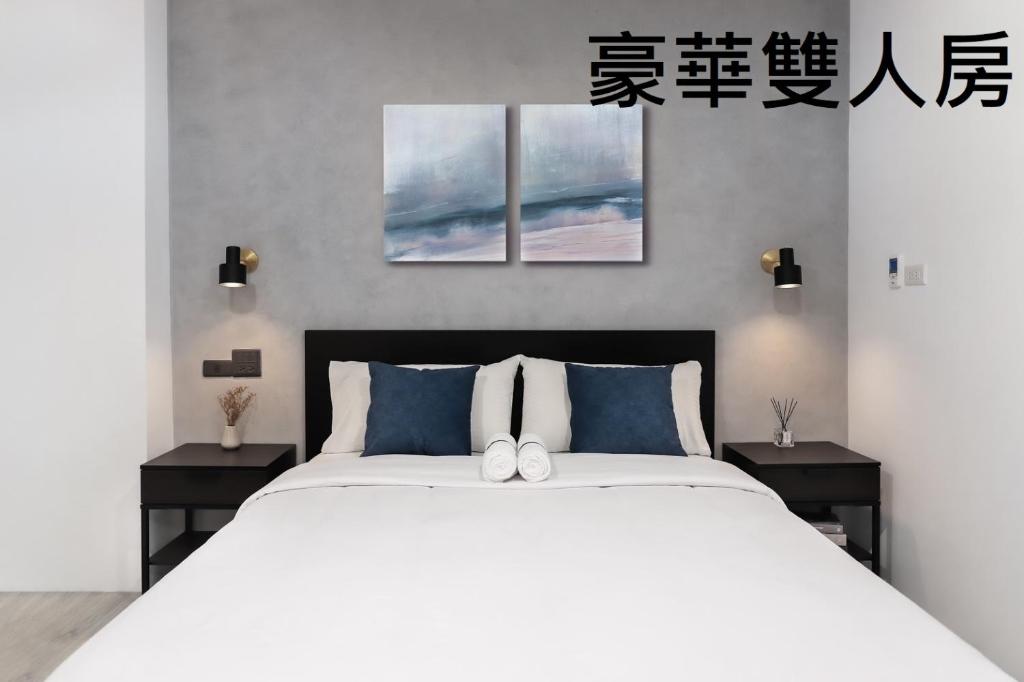 una camera da letto con un grande letto bianco con due tavoli di Tzu Chi Hotel a Città di Pingtung