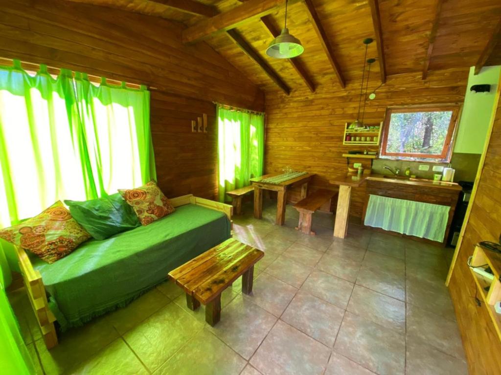 uma sala de estar com um sofá verde e uma mesa em Riberas del Azul em Lago Puelo