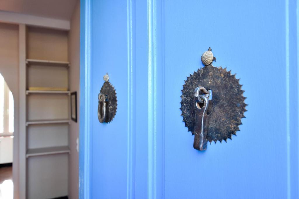 uma porta azul com uma coroa de flores e um par de tesouras em Micoulet, Parking - Clim em Arles