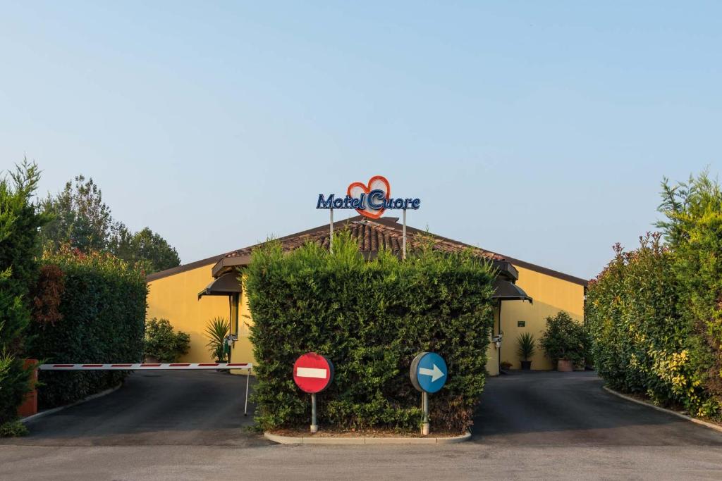 a building with a hedge in front of a street at Motel Cuore Gadesco - Hotel - Motel - Cremona - CR in Ca deʼ Mari