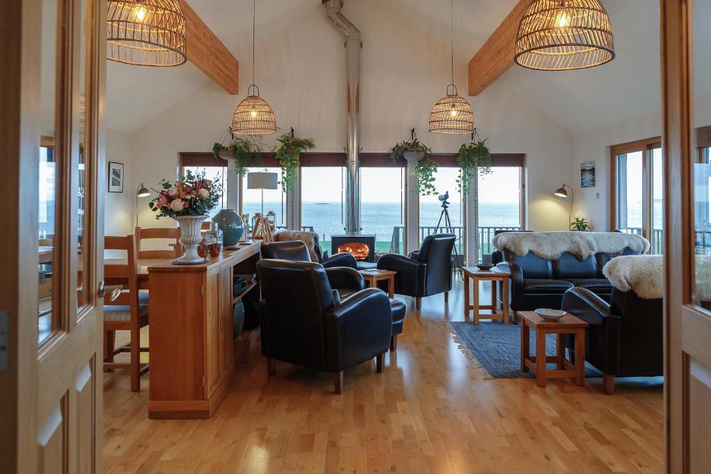 a living room with chairs and a table with a fireplace at Broad Bay House in Stornoway