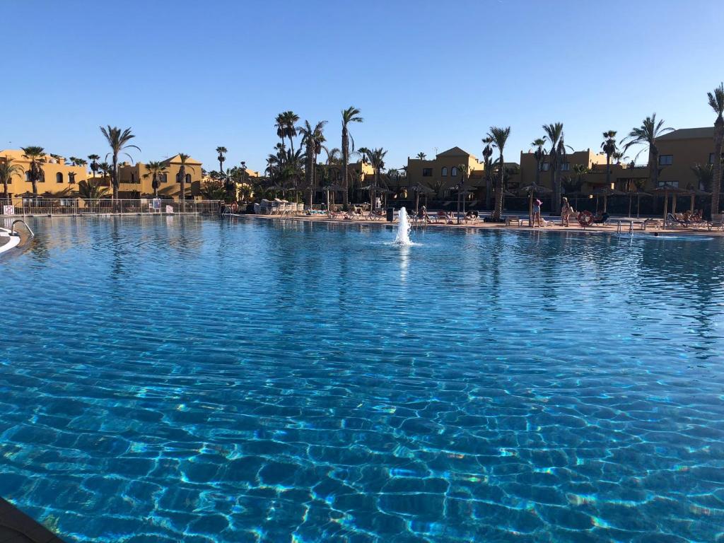 duży basen z błękitną wodą obok plaży w obiekcie Casa Molly w Corralejo