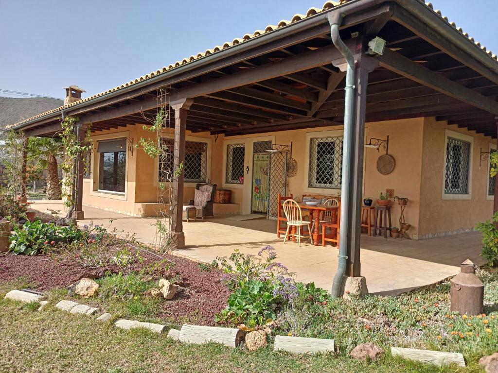 a patio with awning and a table and chairs at Casa del artista in Arona