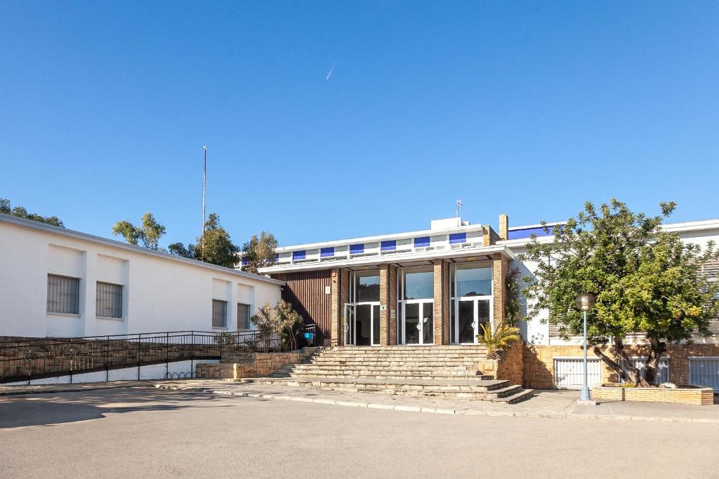 un gran edificio blanco con escaleras delante en Alberg Coma-ruga Xanascat en Comarruga