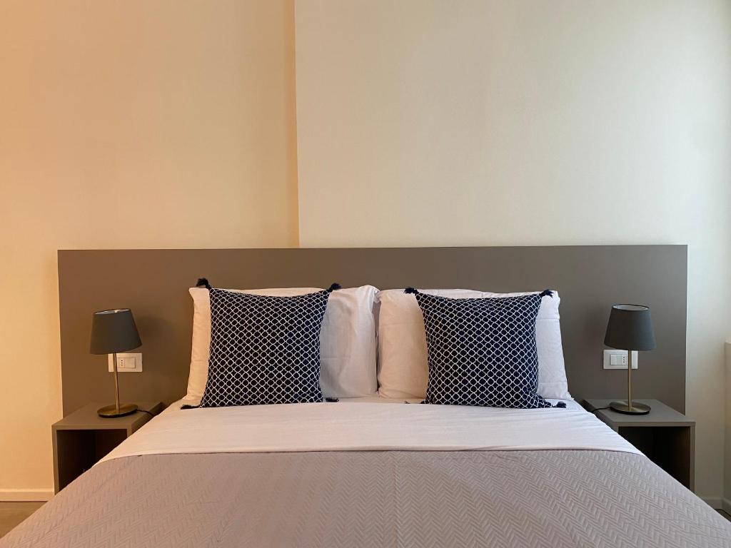 a bedroom with a bed with pillows and two lamps at Residenza SubitoSanto - Appartamento 6A "Galileo" in Padova